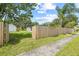 Exterior shot of the home's fenced backyard with a shed, some trees, and a clear view of a sidewalk at 3502 King Richard Ct, Seffner, FL 33584