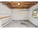 An unfinished basement area with white walls, a wood workbench, exposed rafters, and a small window at 3502 King Richard Ct, Seffner, FL 33584