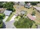 Aerial view of a home with a screened pool, lush lawn, and landscaping at 37147 Foxrun Pl, Zephyrhills, FL 33542