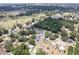 Scenic aerial view of a home nestled among lush trees, featuring a private pool for relaxation and enjoyment at 37147 Foxrun Pl, Zephyrhills, FL 33542