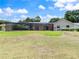 Spacious backyard with a screened-in pool enclosure and lush green lawn at 37147 Foxrun Pl, Zephyrhills, FL 33542