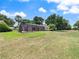 Spacious backyard with large, grassy area and enclosed pool at 37147 Foxrun Pl, Zephyrhills, FL 33542