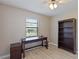 Bedroom with a view, has a wood look floor, a desk with drawers, and a built in shelving unit at 37147 Foxrun Pl, Zephyrhills, FL 33542
