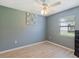 Bedroom featuring wood-look floors, a ceiling fan, an attractive blue accent wall and a window at 37147 Foxrun Pl, Zephyrhills, FL 33542