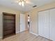 Bright bedroom features wood-look floors, a ceiling fan, large closet, and a built-in shelving unit at 37147 Foxrun Pl, Zephyrhills, FL 33542