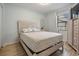 Charming bedroom with wood-look flooring, decorative headboard, and natural light coming from a large window at 37147 Foxrun Pl, Zephyrhills, FL 33542