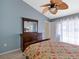 Comfortable bedroom with a dresser, wooden furniture, and natural light, creating a relaxing space at 37147 Foxrun Pl, Zephyrhills, FL 33542
