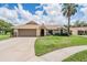Charming single-story home with a well-manicured lawn, two-car garage, and mature landscaping at 37147 Foxrun Pl, Zephyrhills, FL 33542