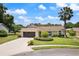 Charming single-story home with a well-manicured lawn, mature landscaping, and a welcoming screened entryway at 37147 Foxrun Pl, Zephyrhills, FL 33542