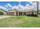 Attractive single-story home with manicured lawn, mature trees, and two-car garage at 37147 Foxrun Pl, Zephyrhills, FL 33542