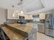 Modern kitchen with stainless steel appliances, breakfast bar, and sleek white cabinetry at 37147 Foxrun Pl, Zephyrhills, FL 33542
