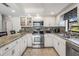 Eat-in kitchen with granite counters, stainless steel appliances, and mosaic tile backsplash at 37147 Foxrun Pl, Zephyrhills, FL 33542