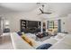 Spacious living room with a modern ceiling fan, white sectional sofa, and large windows overlooking the front yard at 37147 Foxrun Pl, Zephyrhills, FL 33542
