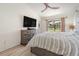 Relaxing main bedroom with a ceiling fan, an entertainment center, and a sliding glass door leading to the pool at 37147 Foxrun Pl, Zephyrhills, FL 33542