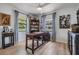 Cozy home office featuring hardwood floors, a large desk, and natural light at 37147 Foxrun Pl, Zephyrhills, FL 33542