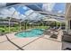 Screened-in pool area with plenty of room for outdoor seating, tropical plants, and a relaxing ambiance at 37147 Foxrun Pl, Zephyrhills, FL 33542
