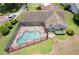 Aerial view showcases a well-maintained pool enclosed by a screen, along with landscaped yard at 37147 Foxrun Pl, Zephyrhills, FL 33542