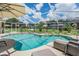 Inviting screened-in pool area surrounded by lush landscaping, perfect for relaxing and entertaining at 37147 Foxrun Pl, Zephyrhills, FL 33542