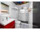 Contemporary bathroom featuring a sleek red vanity, glass-enclosed shower, and stylish fixtures, creating a modern and inviting space at 4050 4Th N St # 116, St Petersburg, FL 33703