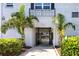 Community entrance with secured gate, mature landscaping and beautiful white brick facade at 4050 4Th N St # 116, St Petersburg, FL 33703