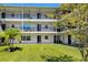 Charming condo exterior with well-maintained lawn, white brick facade, and multiple balconies at 4050 4Th N St # 116, St Petersburg, FL 33703