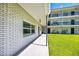 White brick condo exterior with a covered walkway and well-maintained lawn at 4050 4Th N St # 116, St Petersburg, FL 33703