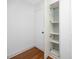 Hallway featuring hardwood floors and a linen closet with glass shelving at 4050 4Th N St # 116, St Petersburg, FL 33703