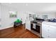 Bright and modern kitchen with stainless steel appliances, quartz countertops, and wood floors, seamlessly connecting to the living area at 4050 4Th N St # 116, St Petersburg, FL 33703