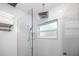 Bright shower with glass enclosure, rainfall shower head and sleek white tiles at 4050 4Th N St # 116, St Petersburg, FL 33703
