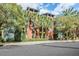 Exterior of a multi-story building featuring red and green hues, surrounded by palm trees and lush greenery at 410 S Armenia Ave # 926, Tampa, FL 33609
