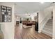 Open-concept living room with a fireplace, wood flooring, and a staircase at 4213 Arborwood Ln, Tampa, FL 33618
