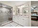Bright main bathroom boasts a double vanity, walk-in shower, and wood-look tile flooring at 4213 Arborwood Ln, Tampa, FL 33618