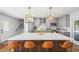A spacious kitchen island with seating and modern light fixtures and stainless steel appliances at 4521 S Cooper Pl, Tampa, FL 33611
