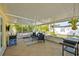 Relaxing screened patio featuring comfortable seating, a grill, and outdoor fan at 4521 S Cooper Pl, Tampa, FL 33611