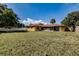 Wide view of the backyard, showing grass, partial home view, and fencing at 5004 S Hesperides St, Tampa, FL 33611