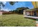 Spacious backyard with green grass and access to a screened-in lanai at 5004 S Hesperides St, Tampa, FL 33611