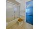 Compact bathroom featuring a shower with sliding glass door and tan colored toilet at 5004 S Hesperides St, Tampa, FL 33611