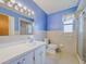 Bathroom with blue walls featuring a vanity, a toilet, and shower at 5004 S Hesperides St, Tampa, FL 33611