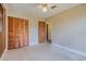 Bedroom with tan walls featuring a ceiling fan and a double closet with wood doors at 5004 S Hesperides St, Tampa, FL 33611