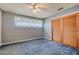 Bedroom with light blue patterned walls and light blue carpet with wooden sliding closet doors at 5004 S Hesperides St, Tampa, FL 33611