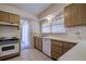 Functional kitchen featuring tile backsplash, white appliances, and wood-look cabinetry at 5004 S Hesperides St, Tampa, FL 33611