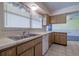 Traditional kitchen featuring wooden cabinets, stainless steel sink, and white appliances at 5004 S Hesperides St, Tampa, FL 33611