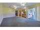 Open living space with a bar top area, sliding doors to the sunroom, and carpet flooring at 5004 S Hesperides St, Tampa, FL 33611