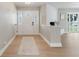 Inviting entryway featuring light wood floors, a decorative front door, and a whitewashed brick accent wall at 521 51St S Ave, St Petersburg, FL 33705