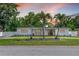 Charming single-story home featuring mature landscaping and a welcoming facade with a black front door at 521 51St S Ave, St Petersburg, FL 33705