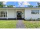 Front of house features modern black door and updated landscaping at 521 51St S Ave, St Petersburg, FL 33705