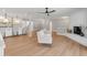 Open-concept living area showcasing light wood floors, a brick fireplace, and seamless flow to the kitchen at 521 51St S Ave, St Petersburg, FL 33705
