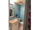 A charming turquoise bathroom with nautical decor, a white vanity, and playful wall art at 7022 Hubert, Tampa, FL 33614