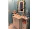 A bathroom featuring white tile floors, vanity, mirror, and decorative vines at 7022 Hubert, Tampa, FL 33614
