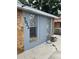 Side view featuring stone detailing, windows, and a hose ready for yard or other outdoor cleaning at 7022 Hubert, Tampa, FL 33614